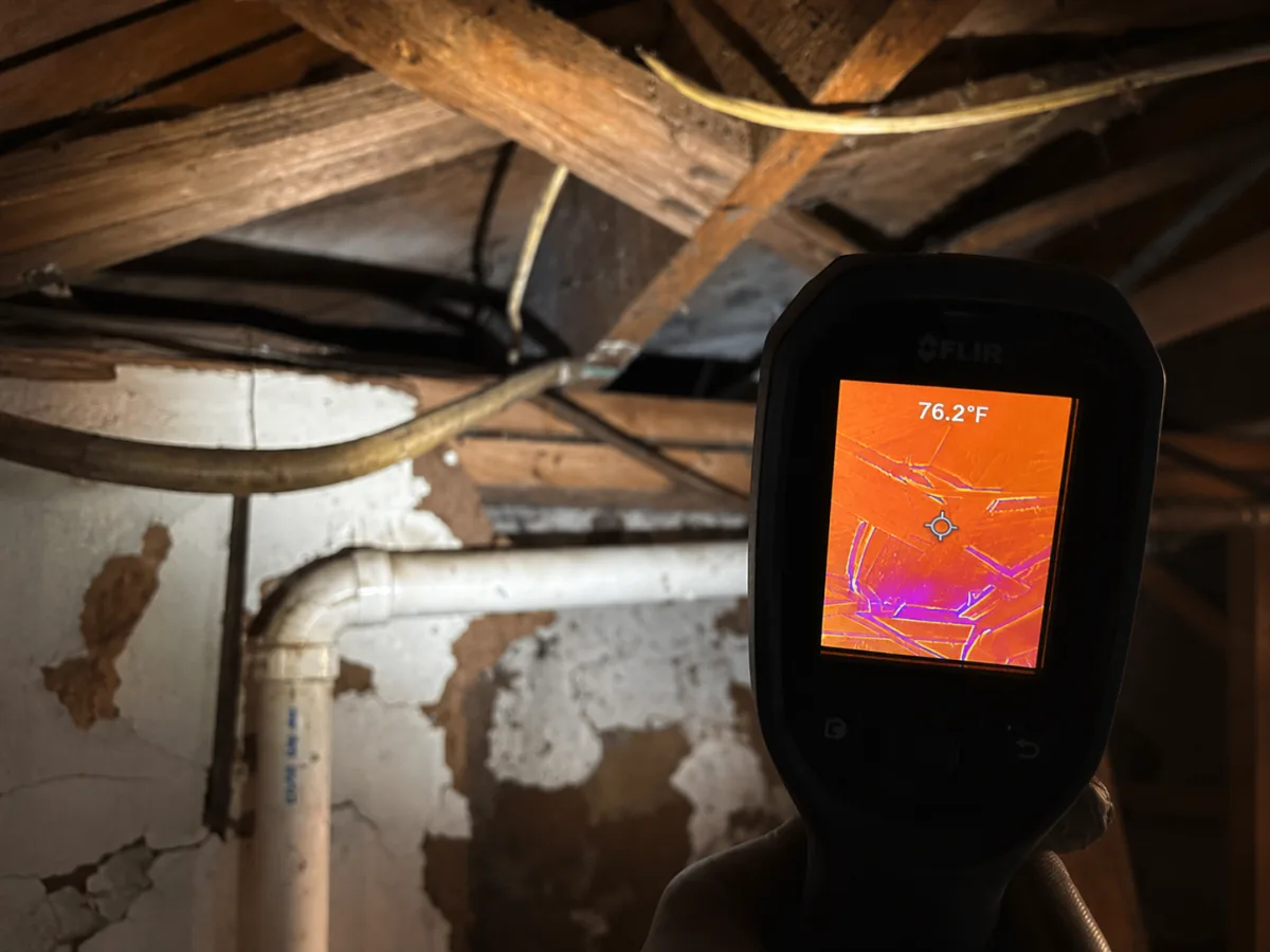 A&G Plumbing technician using a thermal imaging camera to pinpoint a hidden water leak along the pipes in a Metro Atlanta home